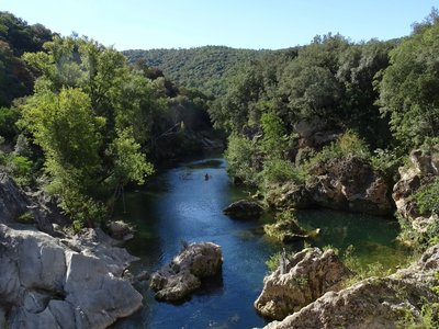Vue sur la rivière entourée de rochers blancs et de végétation verdoyante